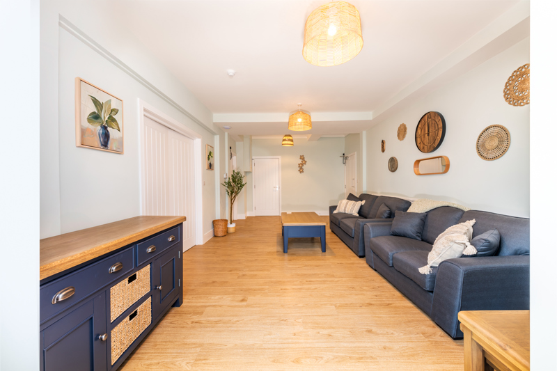 Open-plan lounge at Church Road with navy sofas and a blue sideboard