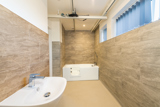 Accessible bathroom at Church Road with a walk-in bath, ceiling hoist track and basin