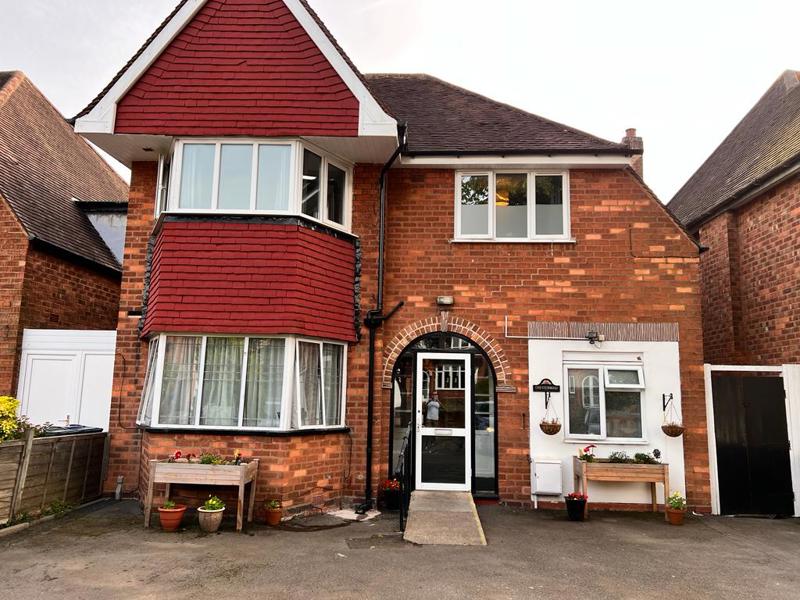 Front of Chesterwood, a red-brick house with bay window, arched porch and planters