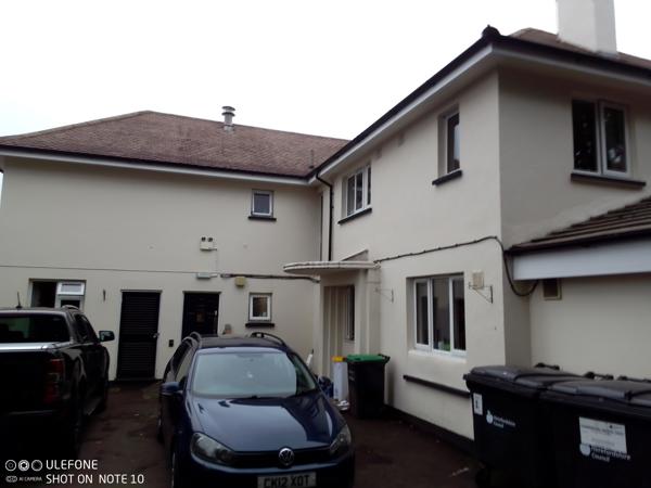 Rear exterior of Chepstow House, a cream two-storey building with parked cars and a tarmac driveway