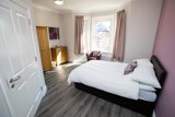 Bedroom at Willow Lodge with a double bed, bay window, oak wardrobe and chest of drawers