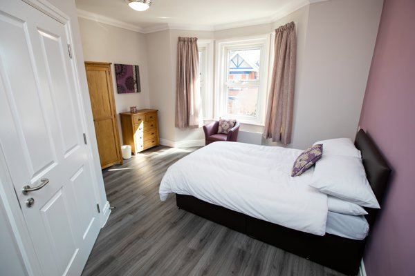 Bedroom at Willow Lodge with a double bed, bay window, oak wardrobe and chest of drawers