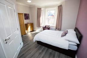 Bedroom at Willow Lodge with a double bed, bay window, oak wardrobe and chest of drawers