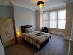 Bedroom at Bayview Lodge with a double bed, wooden wardrobe and a bay window