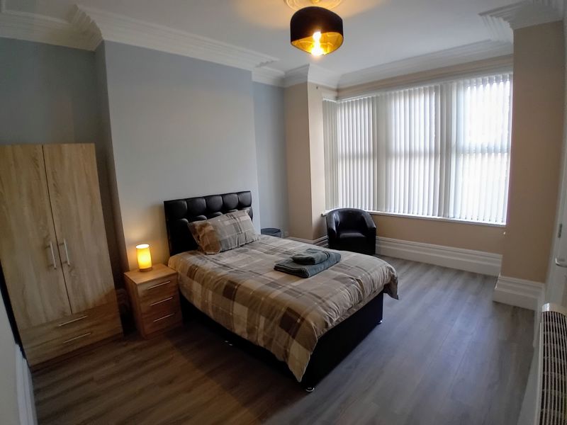 Bedroom at Bayview Lodge with a double bed, wooden wardrobe and a bay window