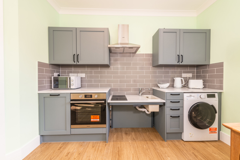 Accessible kitchen at Church Road with grey units, a height-adjustable hob and sink