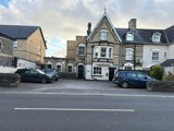 Street view of Manor Lodge from the main road with parking and parked cars