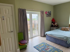 Bedroom at Manor Farm with green walls, French doors to the garden, a bed and soft toys