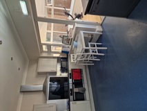 Kitchen at Hazeldene with a double oven, hob, breakfast bar and white stools by the window