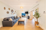 Lounge at Church Road with grey sofas, a coffee table and a conservatory beyond