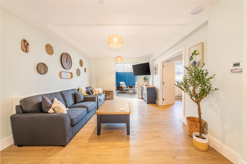 Lounge at Church Road with grey sofas, a coffee table and a conservatory beyond