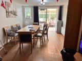 Dining room at Chesterwood with a wooden table, chairs and a conservatory beyond