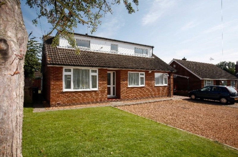 Red brick detached house with front lawn and gravel driveway at Brookside Avenue East