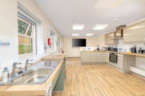 Light and bright kitchen with light coloured wooden flooring.
