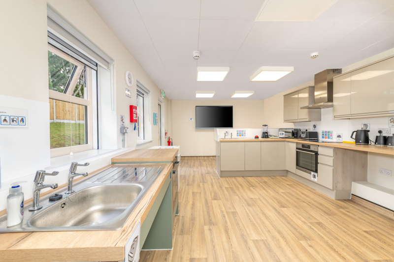 Light and bright kitchen with light coloured wooden flooring.