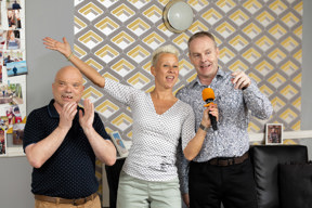 Three people enjoying a karaoke singalong in the lounge at Paddocks, one holding an orange microphone