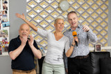 Three people enjoying a karaoke singalong in the lounge at Paddocks, one holding an orange microphone