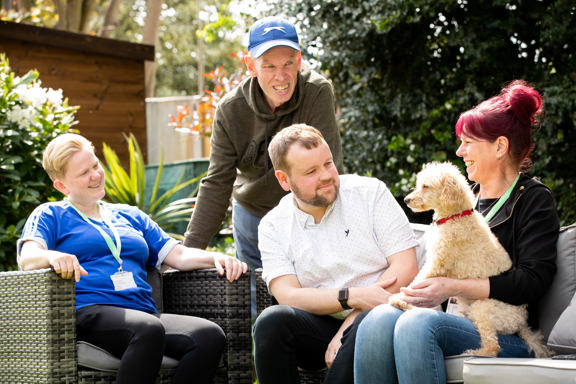 Relaxing in the garden with a pet dog on rattan furniture at Trevelyan