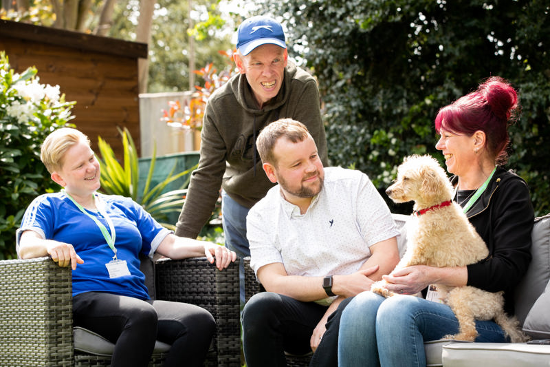 Relaxing in the garden with a pet dog on rattan furniture at Trevelyan