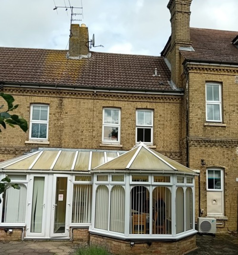 Rear exterior of Eynesbury House, a yellow-brick building with a conservatory and tiled roof