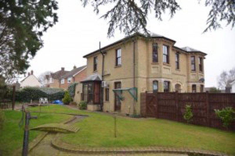 Two-storey detached exterior of Oakley House with a lawned garden and bunting across the front