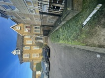 Front exterior of Kemble House, a yellow-brick Victorian building with cars parked on the drive