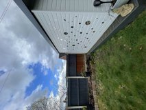 Covered decking and seating area in the rear garden at Glanmore, with a pergola canopy and lawn