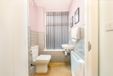 Cloakroom WC at Church Road with a toilet, wall-hung basin and grey tiling