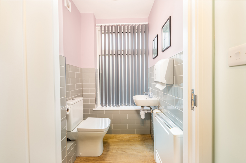 Cloakroom WC at Church Road with a toilet, wall-hung basin and grey tiling