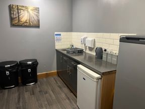 Kitchen area at Byron Lodge with worktop, sink, kettle and tea, coffee and sugar canisters