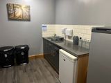 Kitchen area at Byron Lodge with worktop, sink, kettle and tea, coffee and sugar canisters