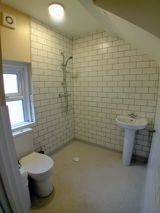 Wet room at Bayview Lodge with a walk-in shower, white metro tiling, toilet and pedestal basin