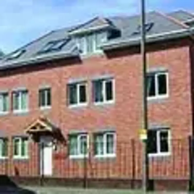 Front exterior of Llys Afon, a red-brick two-storey building with solar panels on the roof