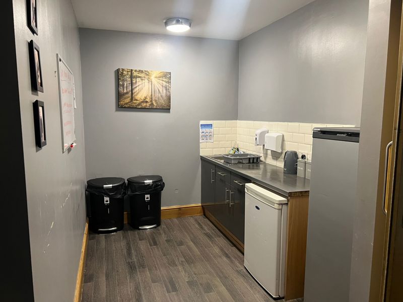 Kitchenette at Byron Lodge with a sink, under-counter fridge and tea and coffee area