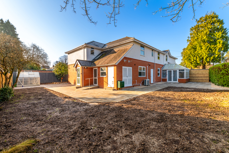 Rear exterior of Church Road with a paved patio, conservatory and large garden