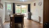 Dining area at Chesterwood with a wooden table, water cooler and doors to the conservatory