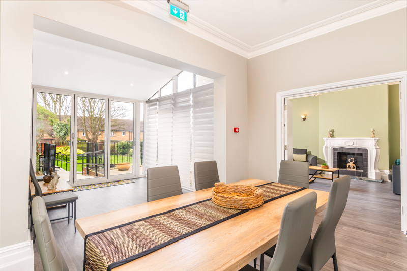 Dining room at Bayview Lodge with a wooden table and patio doors opening onto the garden