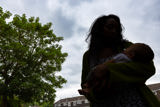 Parent cradling a baby outdoors against a cloudy sky at Clairmont family assessment centre