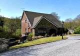 Front exterior of Glan Y Felin, a stone and brick detached house with a slate roof and gravel driveway
