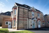 Brick exterior of Willow Lodge, a detached house with red-brick banding, a slate roof and white front doors