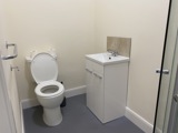 Bathroom at Cranwell Court with a toilet, vanity basin, grab rail and shower cubicle