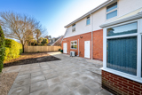Rear patio at Church Road beside the conservatory bay window and red-brick wall