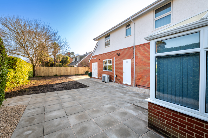 Rear patio at Church Road beside the conservatory bay window and red-brick wall