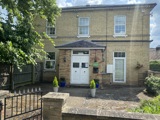 Front of Cranwell Court, a yellow-brick house with a tiled entrance porch and white doors