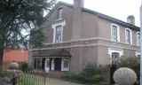 Rendered period detached house at Woodlands with bay windows, a chimney and a cedar tree beside the front path