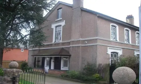 Rendered period detached house at Woodlands with bay windows, a chimney and a cedar tree beside the front path