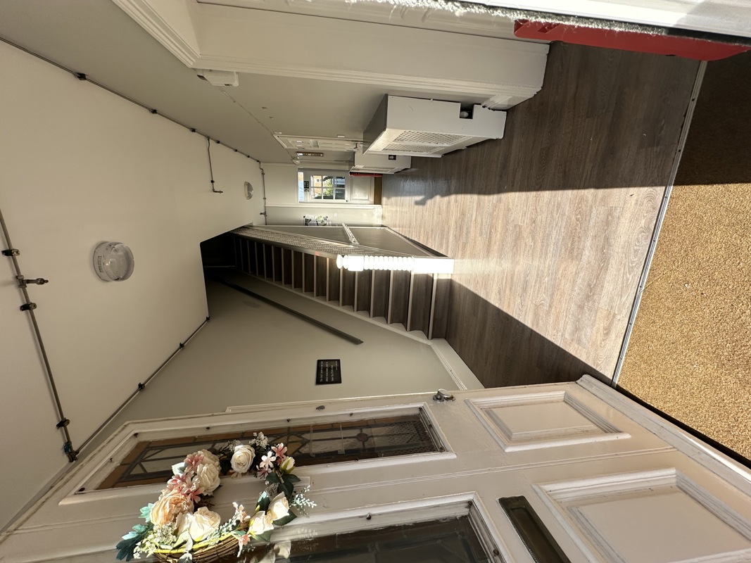 Entrance hallway at Glanmore with a stained glass front door, staircase and wood-effect flooring