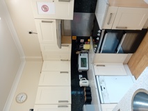 Kitchen at Eynesbury House with cream shaker units, black granite worktops and an oven and microwave