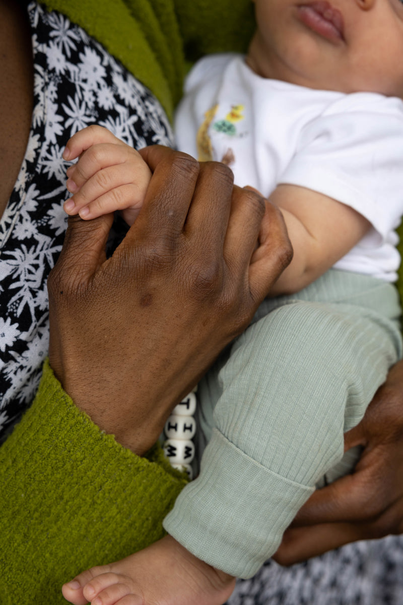 Close-up of a parent holding a baby's hand at Clairmont family assessment centre