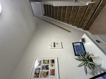 Hallway and staircase at Evergreen with framed resident photo displays and a certificate of caring on the wall